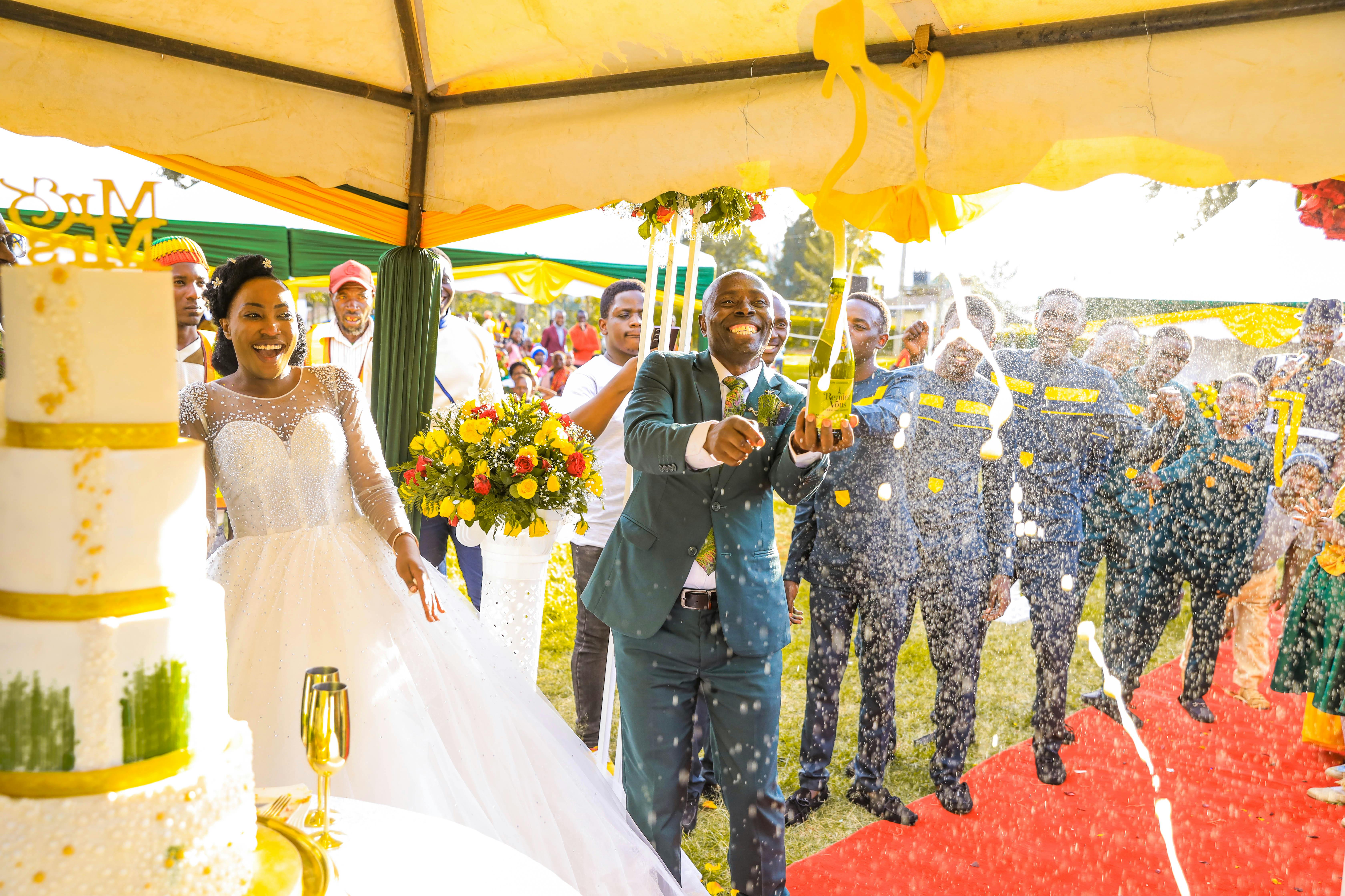 Stylish happy bride and groom toasting with glasses of champagne and having fun